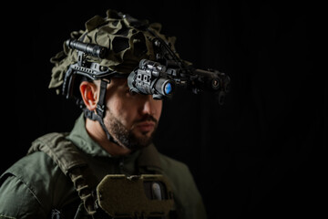 A modern special forces soldier using night vision monocular and thermal imaging in the darkness.