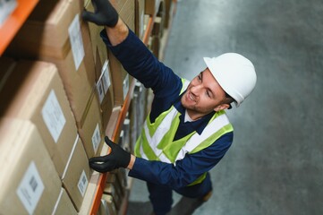 Young man working at a warehouse with boxes