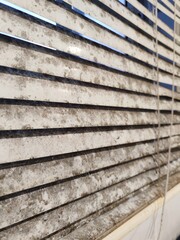 Side view of dirty venetian blinds with grime and mold