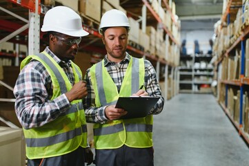 Two warehouse workers checking and controlling boxes in warehouse, Professional warehouse workers