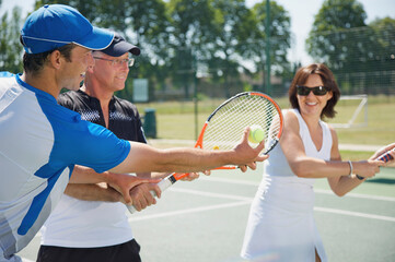 Tennis teacher instructing a couple
