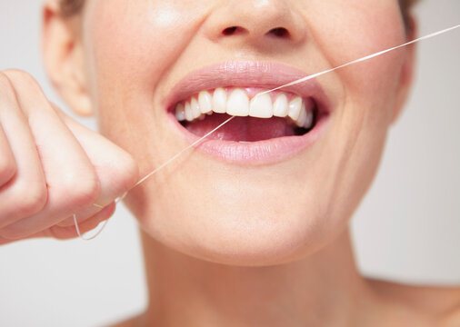 Woman Flossing Teeth - Close-up view
