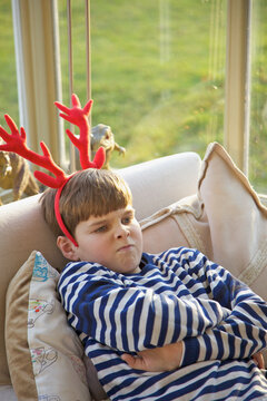 Boy Wearing Christmas Antlers Pulling Faces
