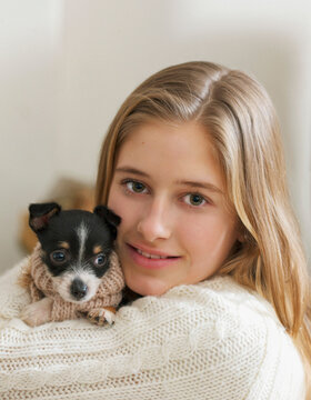 Teenage Girl Hugging Tiny Puppy
