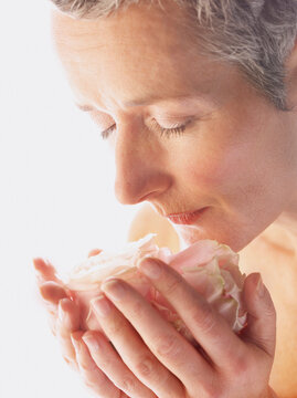 Close up of Mature Woman Smelling Rose
