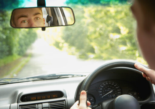 Teenage Boy Looking in Rear View Mirror
