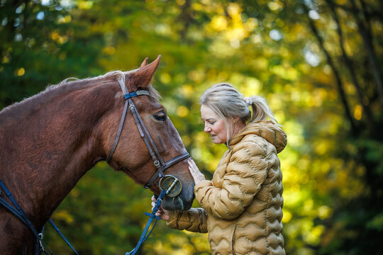 Woman with her horse outdoors. Bonding and friendship between people and animal
