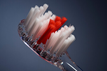 Close up toothbrush with white and red bristles on black background
