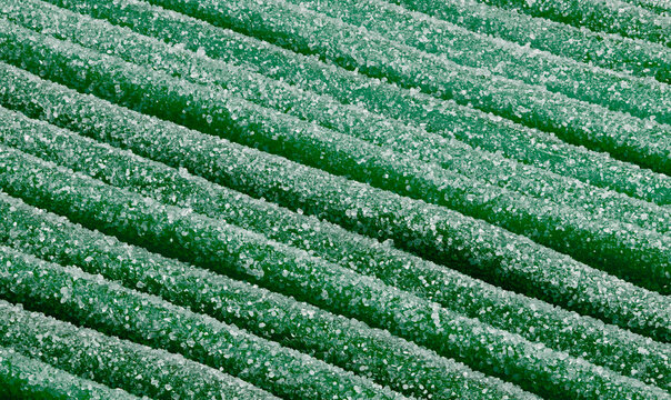 Full frame close up green apple fruit gum candy speckled with sugar crystals
