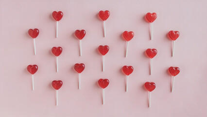Lollipop: Multiple red heart-shaped lollipops scattered elegantly across a soft pink background, perfect for a romantic Valentine's Day theme