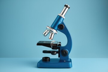 Blue microscope on a blue background  ready for scientific exploration.