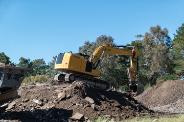 Obraz premium Retroescavadora em ação no carregamento de cascalho para o triturador num cenário de trabalho dinâmico
