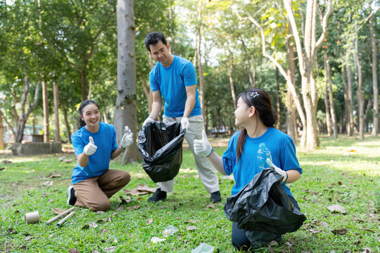 Volunteer family engaging in garbage collection activity in park nature environment community service concept