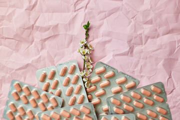 Overhead View of Multiple Blister Packs of Medication on a Crumpled Pink Surface
