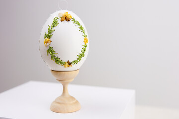 White Easter eggs made with decoupage technique with floral motifs and a flowering branch on a black rustic background. High quality photo