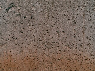 Weathered cement wall with rusty bottom part