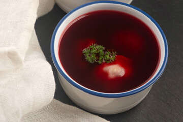 Traditional polish clear red borscht with dumplings with mushrooms