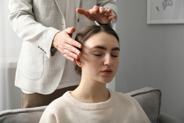 Naklejka premium Psychologist working with patient during hypnosis session indoors, closeup