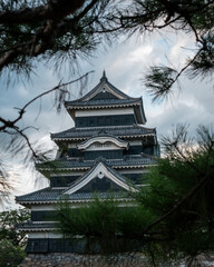 Matsumoto Castle framed by tree leaves