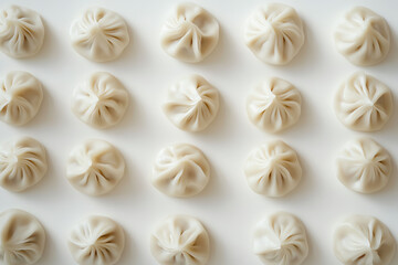 A top view of delicate dumplings arranged neatly on a white background, showcasing their unique shape and texture.