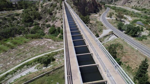 Canal for water transport. Modern aqueduct. Aerial view traveling overhead. Arch bridge. Ca&ntilde;izares Aqueduct. Granada. Spain.