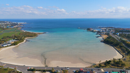 A drone shot of the beautiful emerald sea and clear green waves at Pyoseon Beach in Jeju Island, Korea