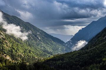 Naklejka premium The Pyrenean valley of Boí in summer, with clouds threatening a storm, a sky full of drama.