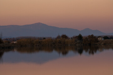 Mountain (Sierra de San Vicente) reflected in the waters of the Tagus River with the warm light of twilight.