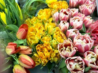 Top view of double tulip bouquets with green leaves on flower shop table as gift concept for Valentine's Day, Birthday, International Women's Day