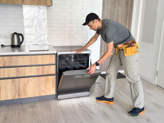 Worker repair dishwasher at home.