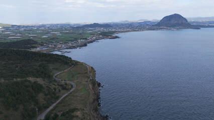 The beautiful harmony of Songaksan Dulle-gil, the sea, and cliffs in Jeju Island, Korea, and the natural scenery taken from the sky with drones