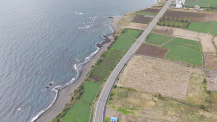 The beautiful harmony of Songaksan Dulle-gil, the sea, and cliffs in Jeju Island, Korea, and the natural scenery taken from the sky with drones