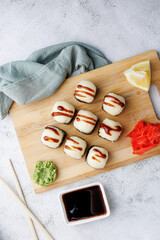 sushi rolls with baked cheese, unagi sauce, sesame, lemon, soy sauce, ginger, wasabi, sushi set on a light background, still life, food, Japanese cuisine, flatlay