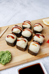 sushi rolls with baked cheese, unagi sauce, sesame, lemon, soy sauce, ginger, wasabi, sushi set on a light background, still life, food, Japanese cuisine, flatlay