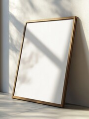 A vertical frame without any artwork leans against a light-colored wall. Soft shadows play across the surface, creating a calming atmosphere in a bright and open space