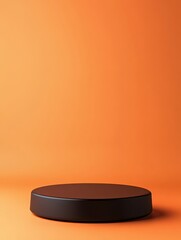 A simple round black platform sits on an orange background. The clean and vibrant colors provide ample copy space, suitable for various design purposes and creative projects. product place