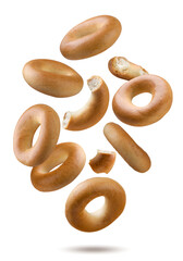 Dry bagels and pieces flying close-up on white. Isolated