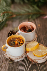 Cozy winter vibes with herbal tea, dried citrus slices, and seasonal decor – Christmas lights and fir tree branches