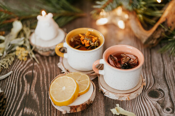 Cozy winter vibes with herbal tea, dried citrus slices, and seasonal decor – Christmas lights and fir tree branches