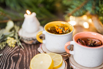 Cozy winter vibes with herbal tea, dried citrus slices, and seasonal decor – Christmas lights and fir tree branches