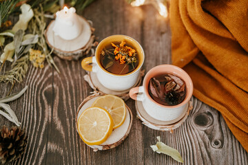 Cozy winter vibes with herbal tea, dried citrus slices, and seasonal decor – Christmas lights and fir tree branches