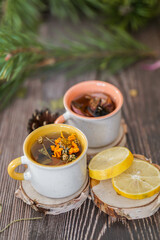 Cozy winter vibes with herbal tea, dried citrus slices, and seasonal decor – Christmas lights and fir tree branches