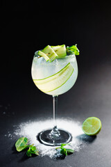 Transparent refreshing drink with cucumber, lemon and basil. Selective focus.