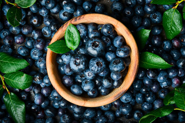 A bowl of blueberries. Fresh berries and leaves. Vitamins and berries. Top view.