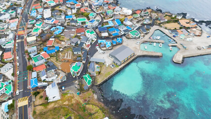 The beautiful emerald sea and waves in Dongbok-ri, Gujwa-eup, Jeju Island's attraction. The view taken with a drone in the sky