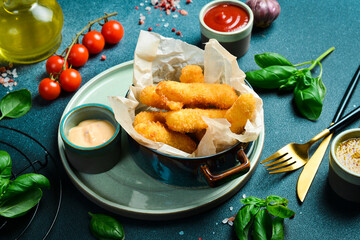 Deep-fried cheese sticks with burger sauce. Close up. on a plate On a black stone background.