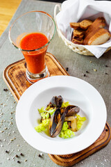 Tomato and seafood creamy soup with mussels. On a wooden background.