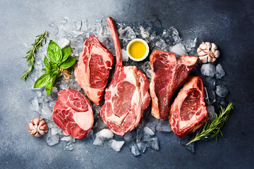 Raw Prime Black Angus steaks for grilling with seasoning: Tomahawk steak, Ribeye, T-bone and...