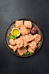 Dry vegan meat. Soy meat in a plate. On a black textured background. Top view.