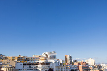 Photo of the Spanish town of Torremolinos in Spain showing rows of hotels and apartments in the town in Spain on a sunny day with a clear blue sky